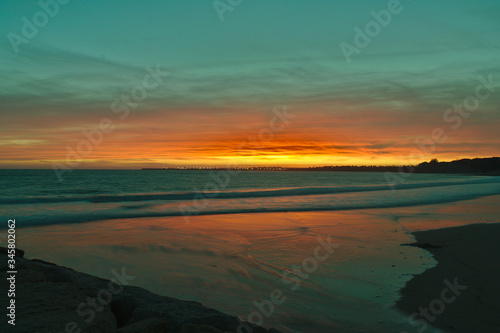 Beautiful Sunset, Orange and Turquoise Reflecting off the sea and waves down on the beach at El Puerto de Santa Maria