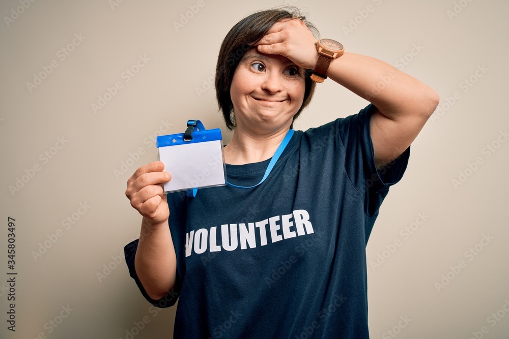 Young down syndrome volunteer woman wearing social care charity t-shirt showing identification stressed with hand on head, shocked with shame and surprise face, angry and frustrated. Fear and upset Young down syndrome volunteer woman wearing social care charity t-shirt showing identification stressed with hand on head, shocked with shame and surprise face, angry and frustrated. Fear and upset