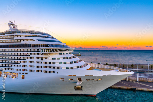 Front/ Bow of Cruise Ship docked/ anchored/ moored in Port. Colorful sunset sky glow on horizon in background. © Debbie Ann Powell