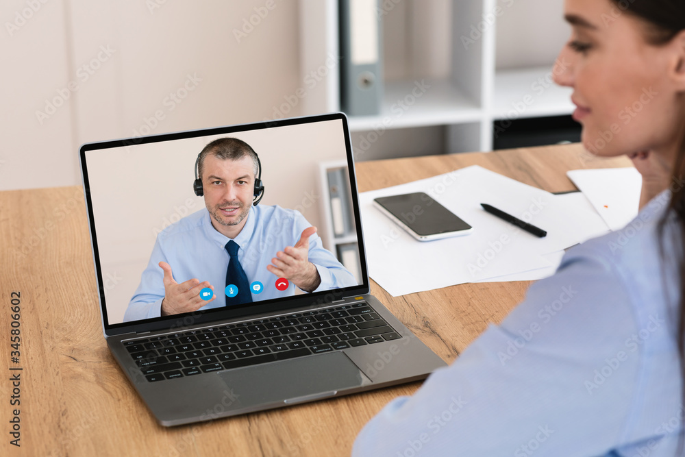 Businesswoman Having Online Meeting With Coworker Sitting In Office Businesswoman Having Online Meeting With Coworker Sitting In Office