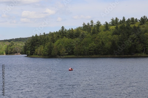 A view of a kayaker on a beautiful New Hampshire lake in summer.