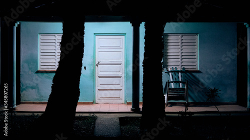 Turquoise building facade with white door and windows