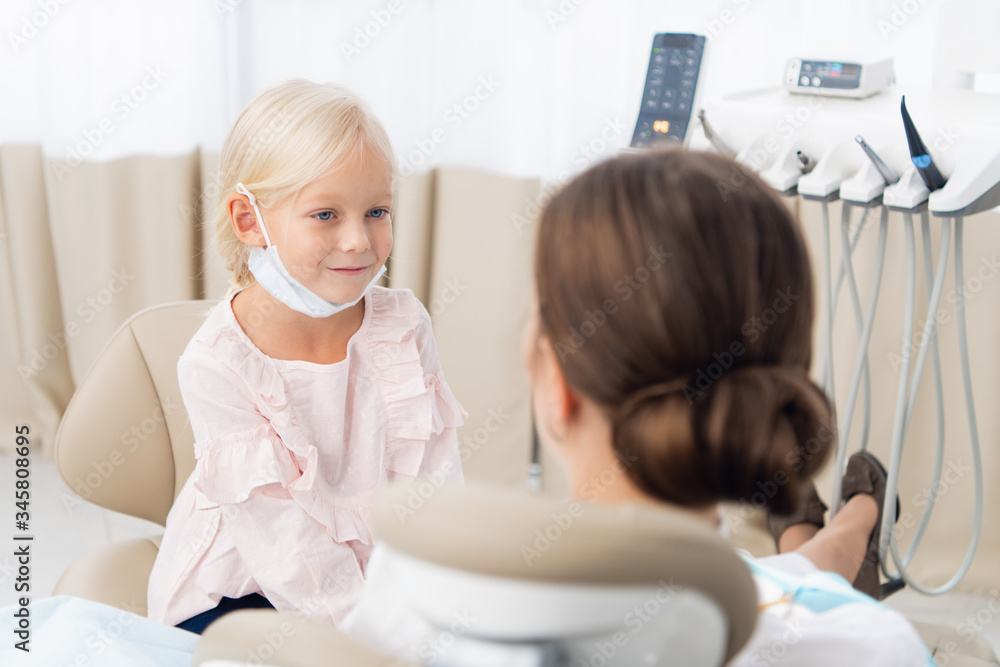 Little girl sitting and smiling in the dentists office. Child no