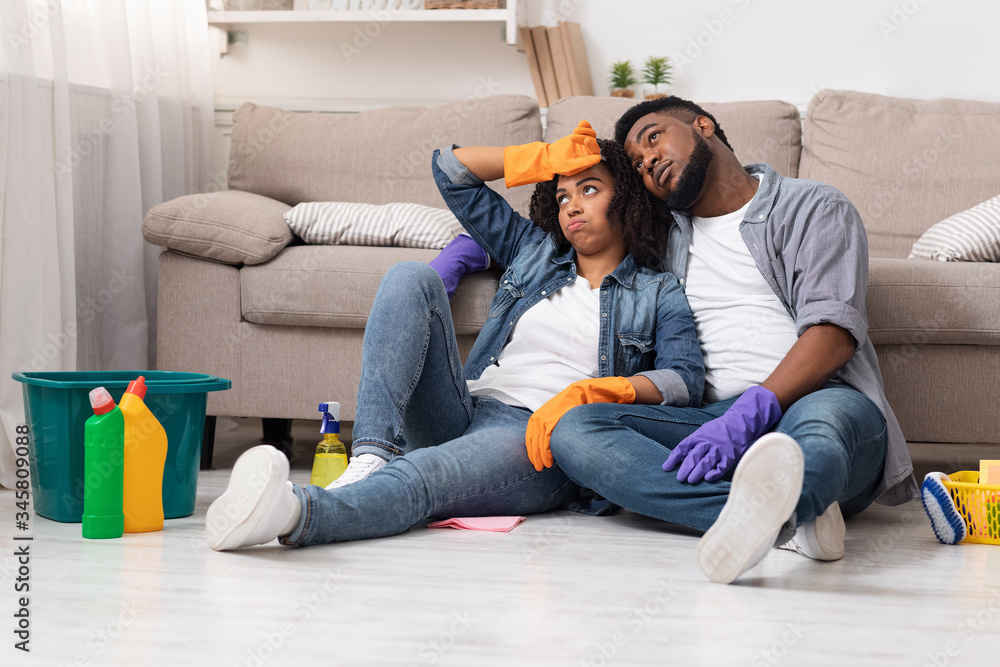 Exhausting Spring-Cleaning. Tired african couple resting on floor after tidying flat Exhausting Spring-Cleaning. Tired african couple resting on floor after tidying flat