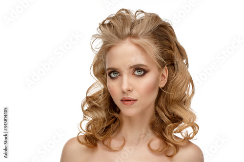 Curly blonde hair. Woman with wavy hair. Volume in the hair. Shiny, healthy salts. Advertising shampoo, bolsam, masks or hair styling products.