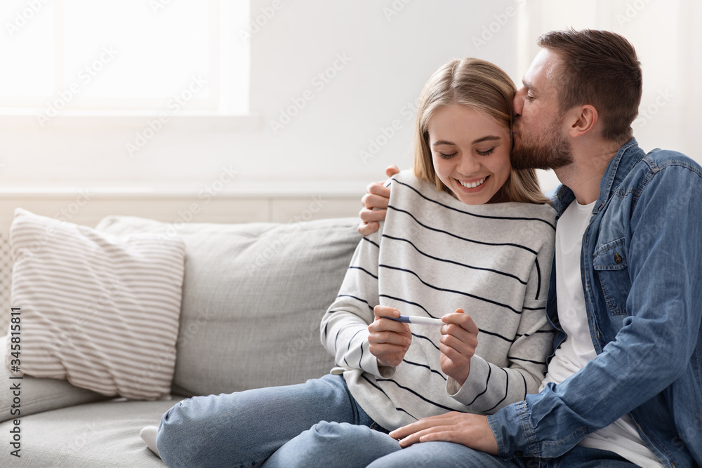 Young couple happy about positive results of pregnancy test