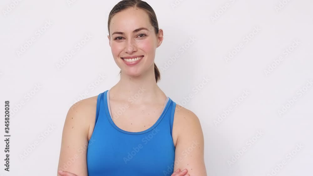 Portrait of sporty smiling girl looking into the camera, showing how strong she got by doing exercise Portrait of sporty smiling girl looking into the camera, showing how strong she got by doing exercise