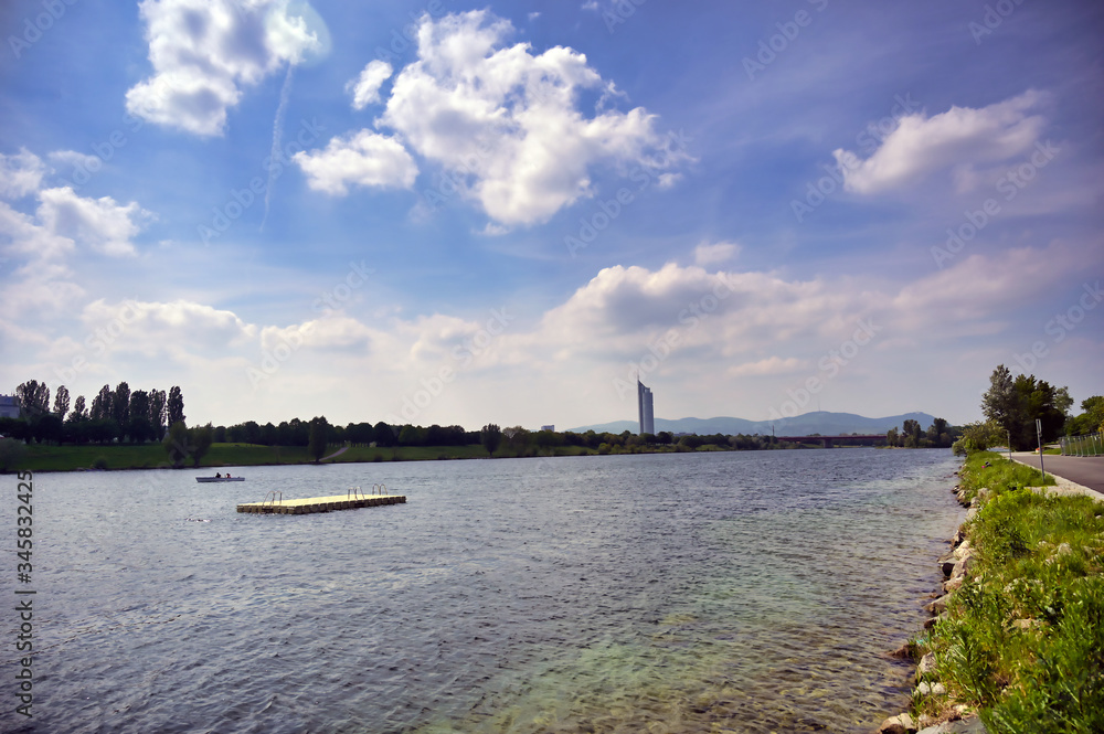 The Danube River runs through the city of Vienna, Austria on a sunny day.