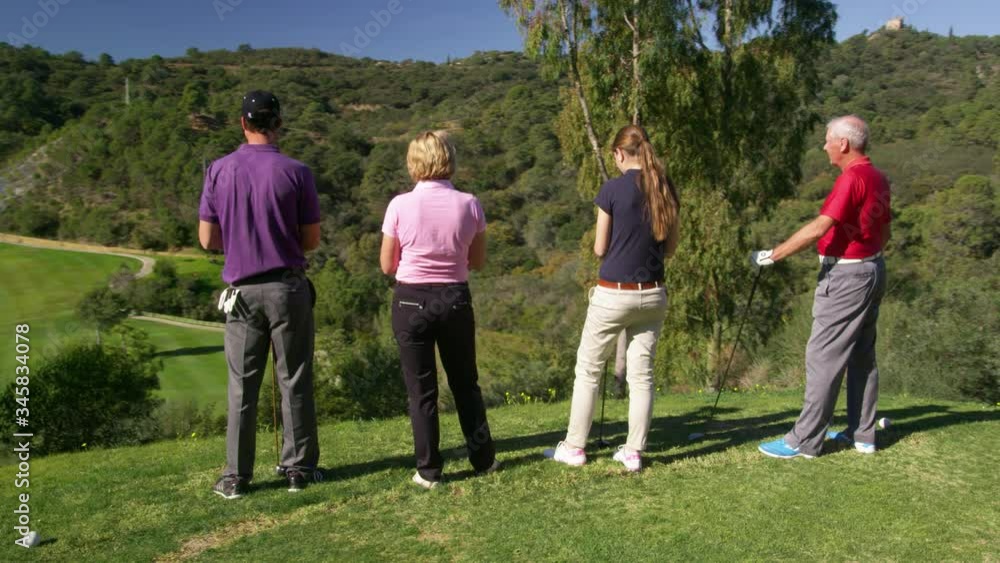 WS DS MS Four golfers standing at golf course WS DS MS Four golfers standing at golf course