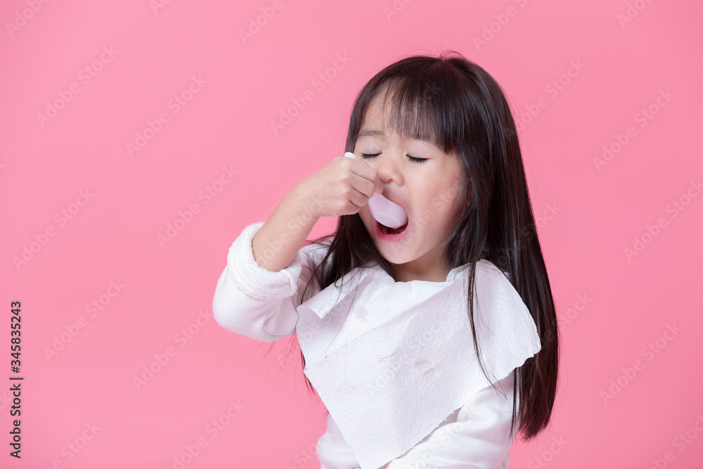 Little girl going to eat food by plastics spoon with a tissue made into an apron in pink background. Little girl going to eat food by plastics spoon with a tissue made into an apron in pink background.