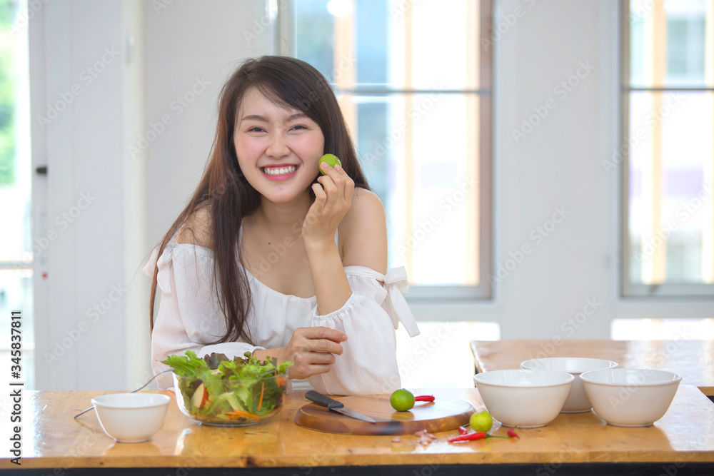 Beautiful Asian women, beautiful smiles, good health, beautiful teeth, eating salad vegetable when working at home. Beautiful Asian women, beautiful smiles, good health, beautiful teeth, eating salad vegetable when working at home.