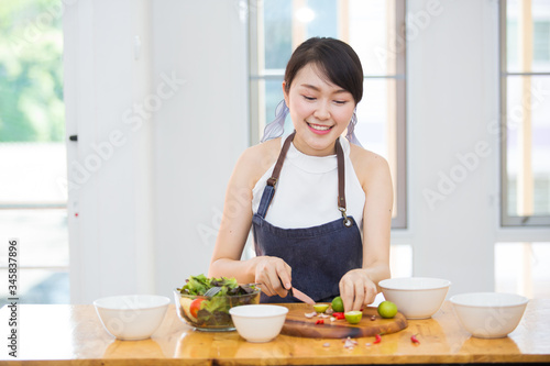Beautiful Asian women  beautiful smiles  good health  beautiful teeth  eating salad vegetable when working at home.