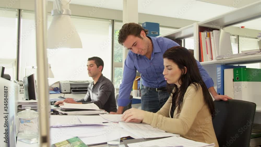 WS Three people working at desk in office WS Three people working at desk in office