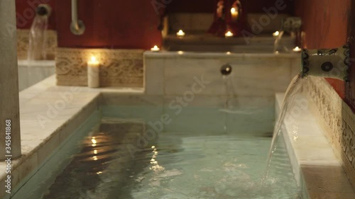 MS Water pouring from faucets into bathtub in traditional Arab bathhouse (hammam) photo