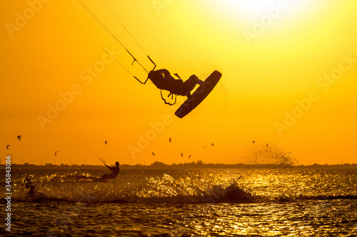 Professional kiter rides in the ocean against the background of incredible setting sun © ohrim