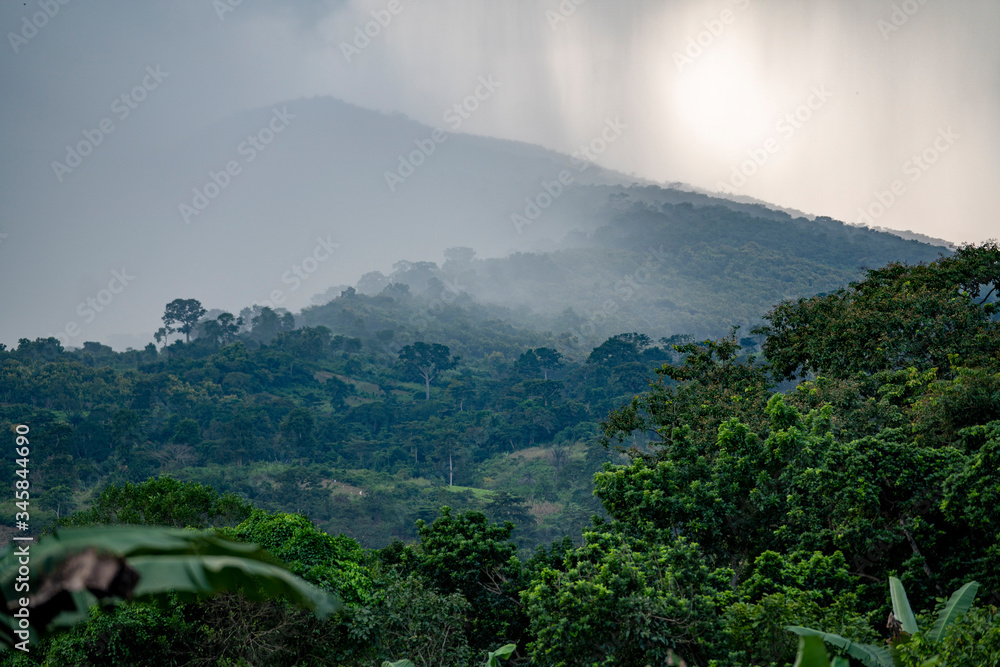 Rain squalls drench a mountain side in the jungles of  tropical West Africa in Ghana.