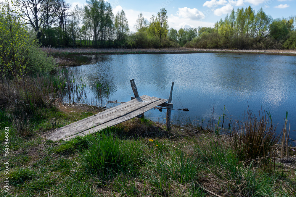 Fototapeta premium Old rustic wooden jetty on a tranquil lake
