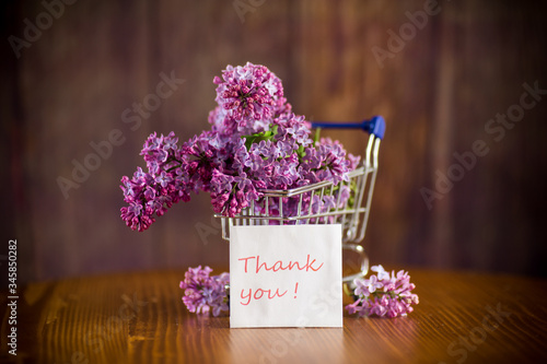 bouquet of spring blossoming lilacs in a shopping cart