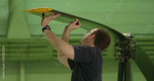 MS Aviation mechanic performing tapping inspection of helicopter rotor blade