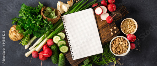 Diet Food Concept. Healthy vegan eating. Blank notebook with fresh vegetables, herbs, cereal and nuts. Veggie Cooking