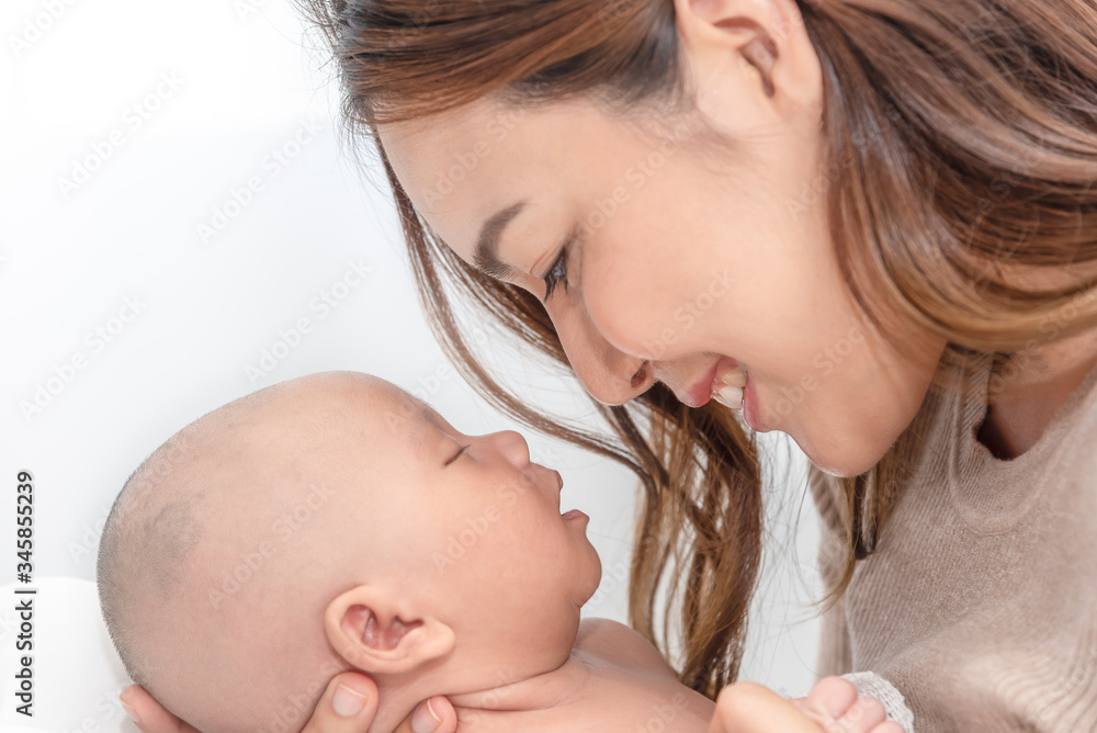 Close up beautiful young asian mother holding her newborn one month baby sleep on her lap. Healthcare and medical. Lovely asian woman lifestyle mother's day concept. Close up beautiful young asian mother holding her newborn one month baby sleep on her lap. Healthcare and medical. Lovely asian woman lifestyle mother's day concept.