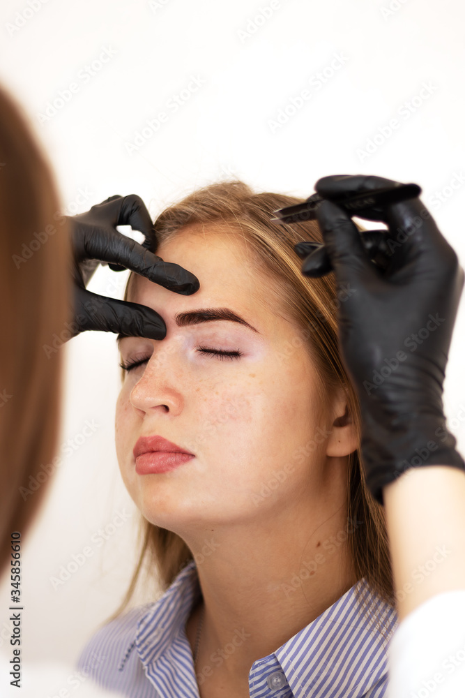 A female cosmetologist performs eyebrow correction on a beautiful model in a beauty salon. Facial and salon treatments. Model with vitiligo pigmentation. Safe tinting eyebrows with henna A female cosmetologist performs eyebrow correction on a beautiful model in a beauty salon. Facial and salon treatments. Model with vitiligo pigmentation. Safe tinting eyebrows with henna