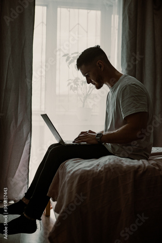 guy using laptop on a bed