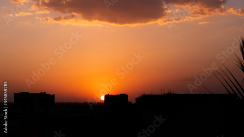 a sunset in city buildings silhouette