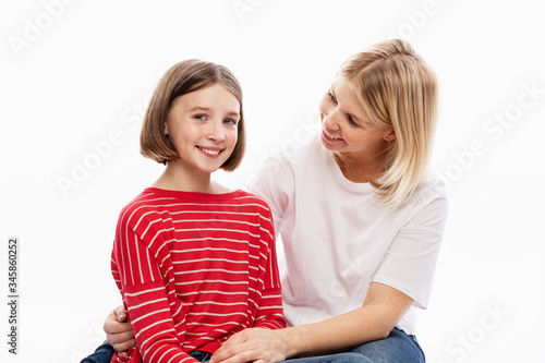 Daughter teenager and mother laugh and hug. Love and support in family relationships. White background. Space for text.