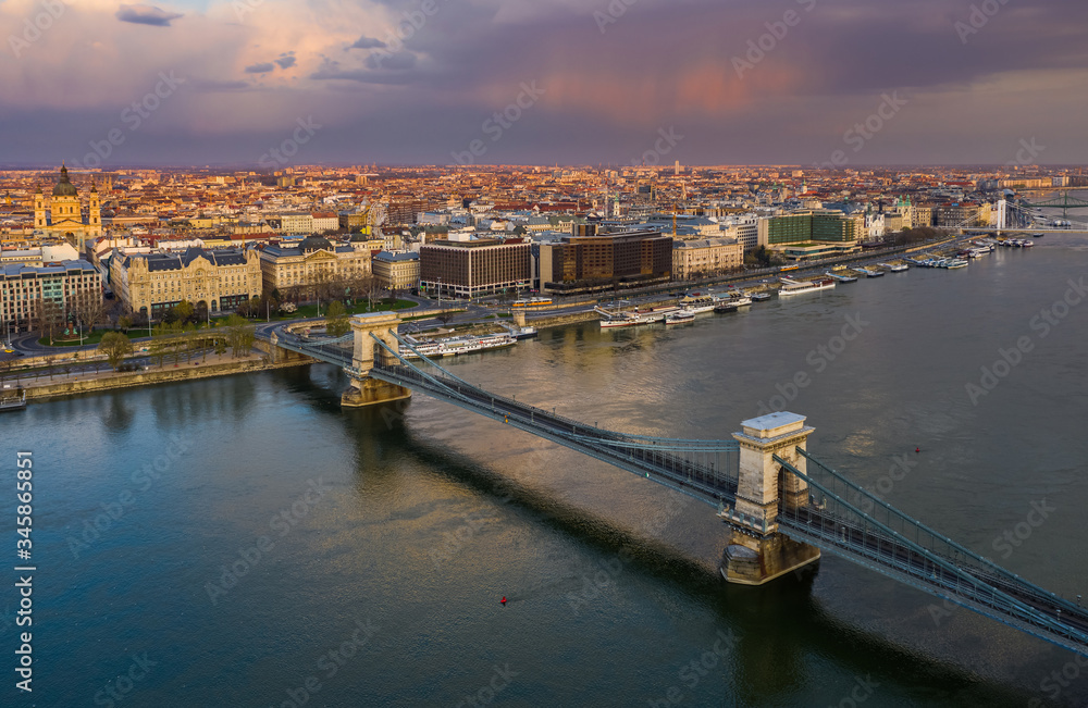 Budapest, Hungary - Aerial view of the Szechenyi Chain Bridge at sunset with colorful sky and St.Stephen's Basilica. The bridge and the streets are totally empty due to 2020 Coronavirus quarantine