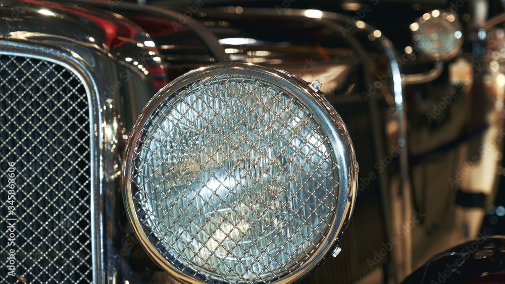 Close-up view of black vintage car headlight with chrome bezel