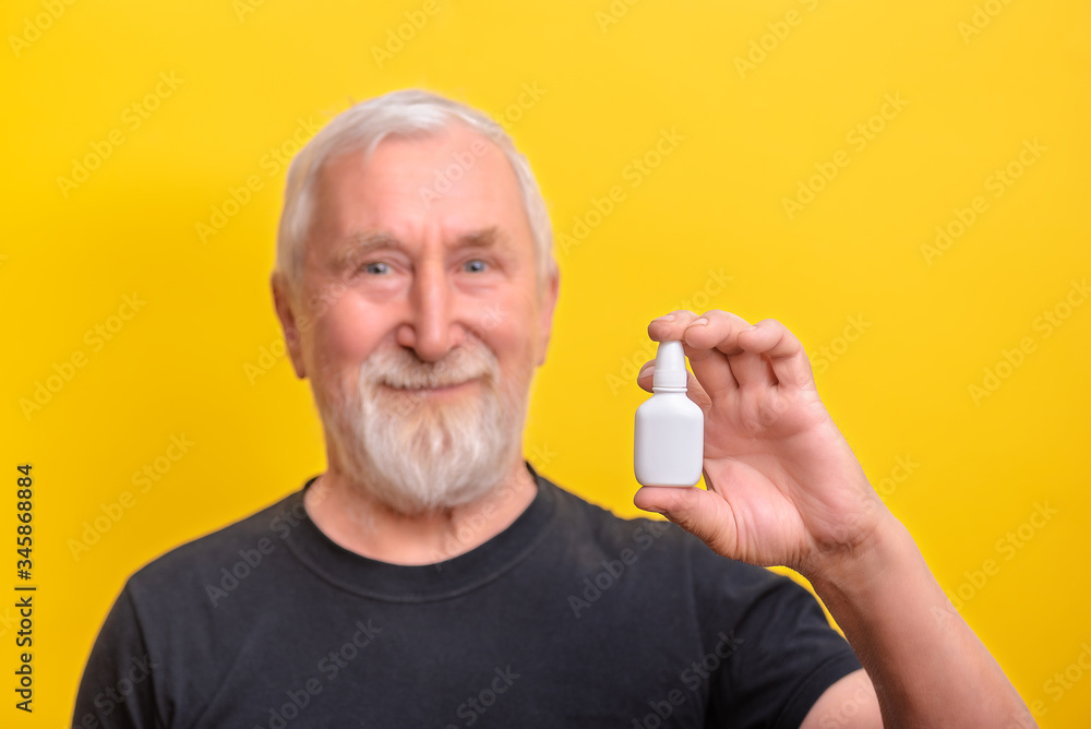 Senior man is holding nasal spray copy space and mock up. sarcasm emotion Senior man is holding nasal spray copy space and mock up. sarcasm emotion