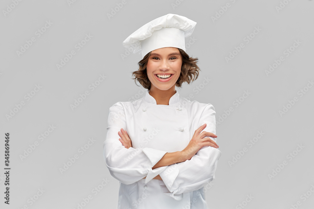 cooking, culinary and people concept - happy smiling female chef in toque with crossed arms over grey background - obrazy, fototapety, plakaty 