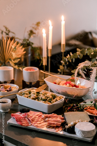 An assortment of food appertizers set up on a dark surfaced table for a house party