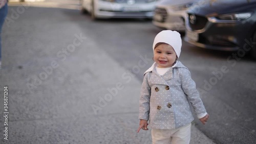 Cute little girl in grey coat play with little dog outside. Yorkshire terrer play and jump. Adorable girl have fun with pet photo