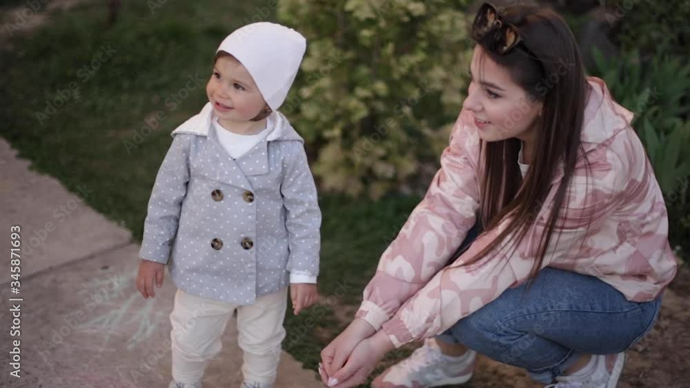 Cute little girl with her mom play with little dog outside. Yorkshire terrer play and jump. Adorable girl ave fun with pet Cute little girl with her mom play with little dog outside. Yorkshire terrer play and jump. Adorable girl ave fun with pet