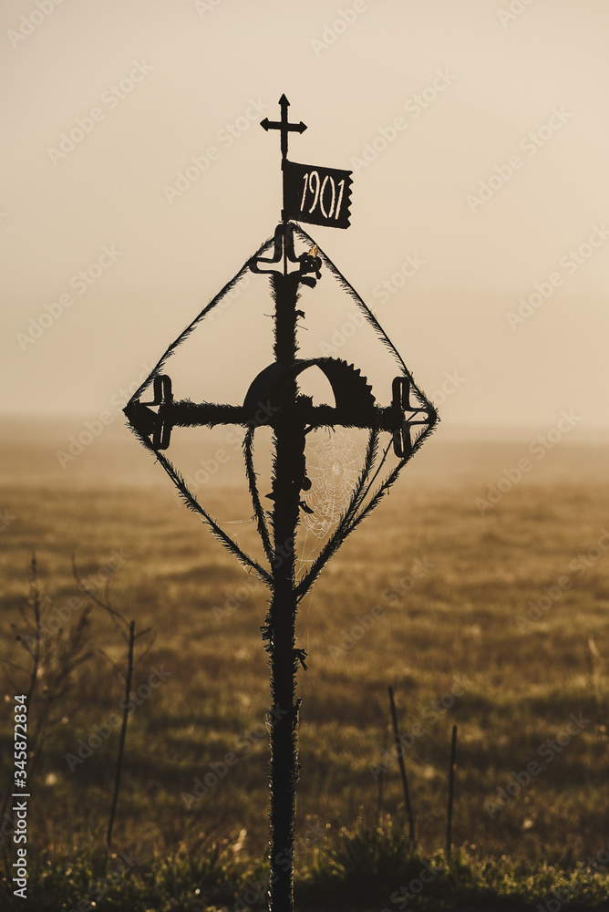 Obraz premium Cross by the road. Old chapel. Spider web and sun rise.