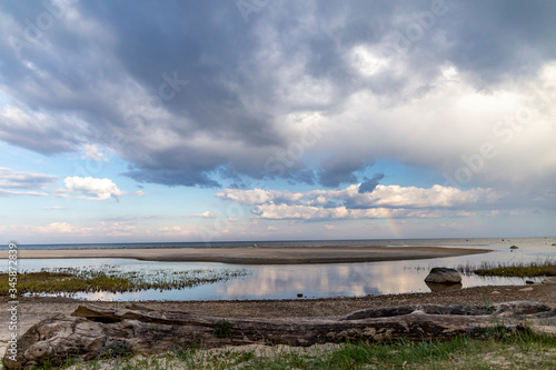 Rainbow over the sea with cloudy skies on a sunny day in spring.