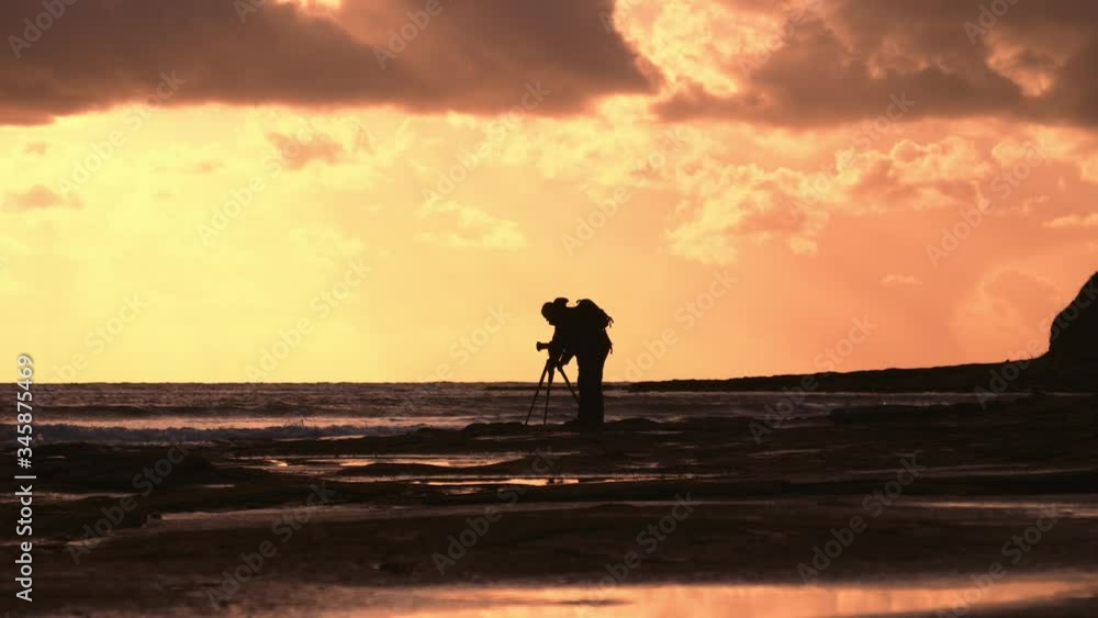 Photographer with camera on tripod during sunset down Kimmeridge Bay, Dorset. Photographer with camera on tripod during sunset down Kimmeridge Bay, Dorset.