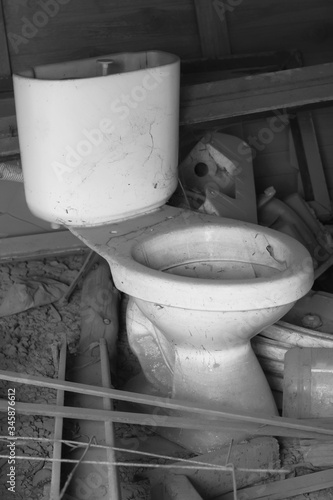 discarded Toilet bowl that is no longer in use,Black and white