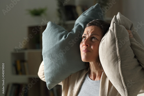 Annoyed adult woman suffering neighbour noise at night at home photo