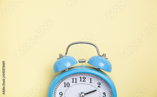 Alarm clock on yellow background. Top view
