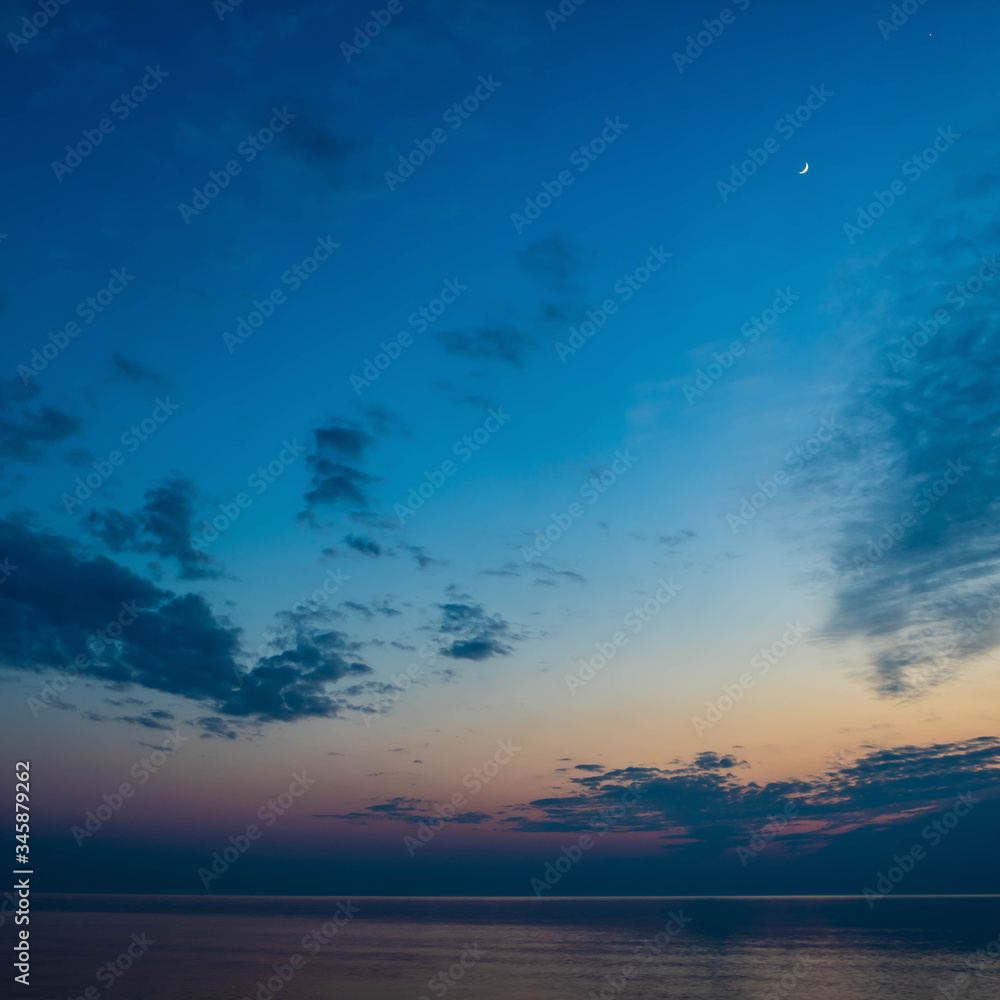 Beautiful scenery of Baltic sea. Cloudy weather. Soft focus of the sea. Moon in the night sky. Beautiful scenery of Baltic sea. Cloudy weather. Soft focus of the sea. Moon in the night sky.