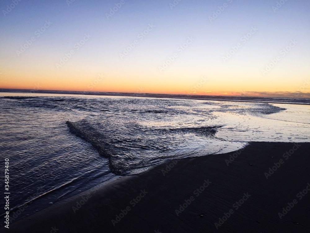 Scenic View Of Beach Against Clear Sky During Sunset