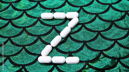 Obraz na płótnie Alphabet made of pills on a green and black background. Vitamins on a background of scales. Abc from drugs. Letter Z made from pills. Capital letter Z of medicines w salonie
