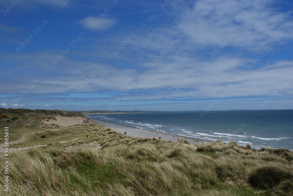 Panoramic view of windswept beach on a sunny day in County Down, Northern Ireland. 