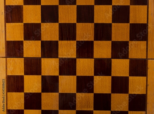 Top view of empty chess board made of wood.Texture of chess board
