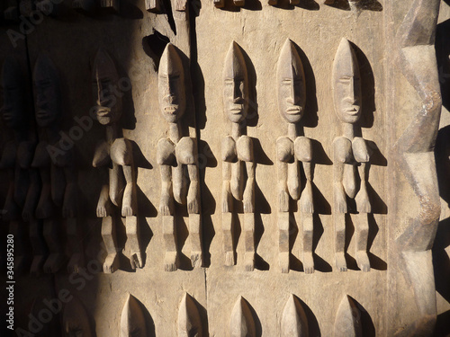 stara tradycyjna afrykańska płaskorzeźba na drewnianych drzwiach budynku w timbuktu przedstawiająca ludzkie postaci