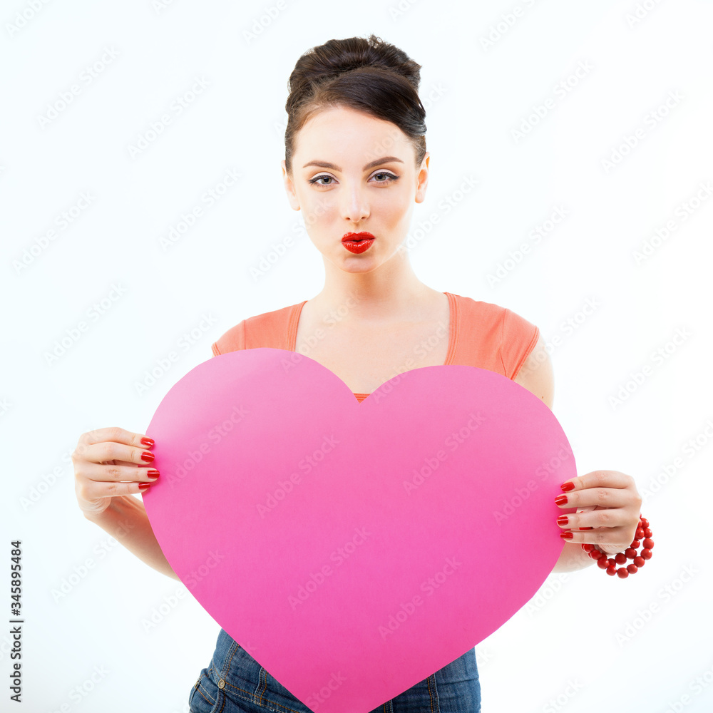 Pinup girl holding pink heart and happy smiling. Retro portrait of young cheerful woman in pin-up style, vintage stylization over white. Love symbol, St. Valentine Day, feeling concept Pinup girl holding pink heart and happy smiling. Retro portrait of young cheerful woman in pin-up style, vintage stylization over white. Love symbol, St. Valentine Day, feeling concept