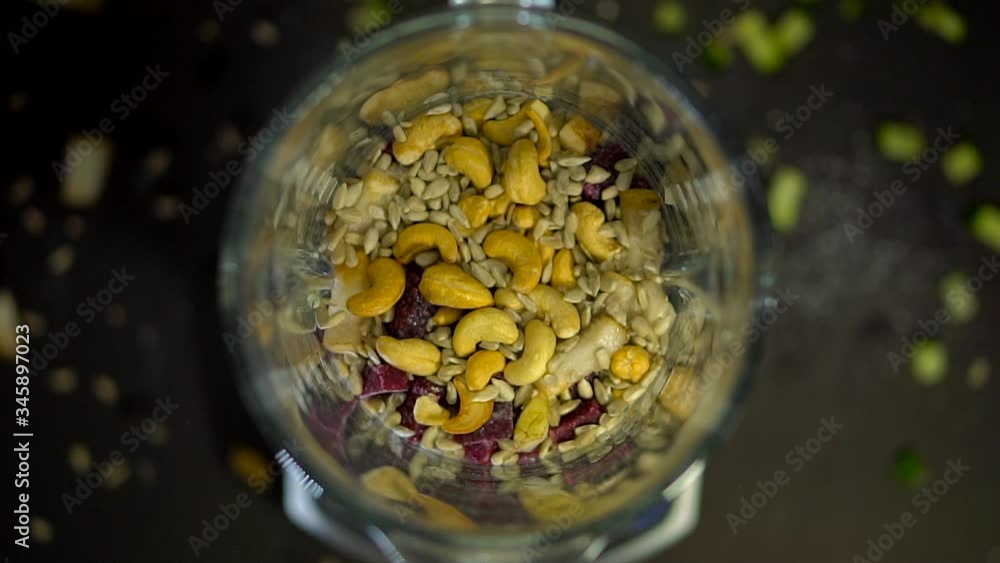 In a smoothie with nuts and seeds, a spoonful of lemon juice or oil. The process of making smoothies in a mixer, berry puree, Smoothie Bowl. Proper nutrition in the mixer In a smoothie with nuts and seeds, a spoonful of lemon juice or oil. The process of making smoothies in a mixer, berry puree, Smoothie Bowl. Proper nutrition in the mixer